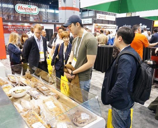 Members of the Korean buyers team learn about U.S. pork cuts and processed pork items at the National Restaurant Association Show in Chicago